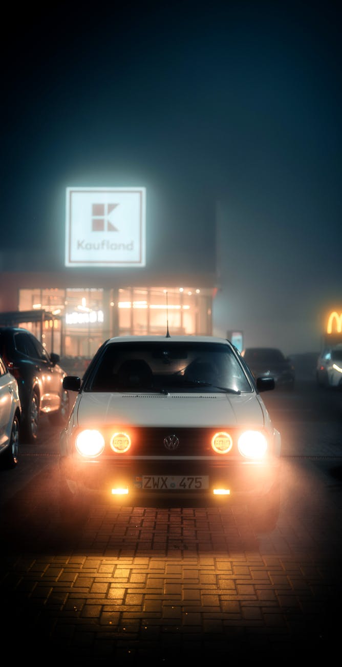 nighttime scene with car in foggy parking lot