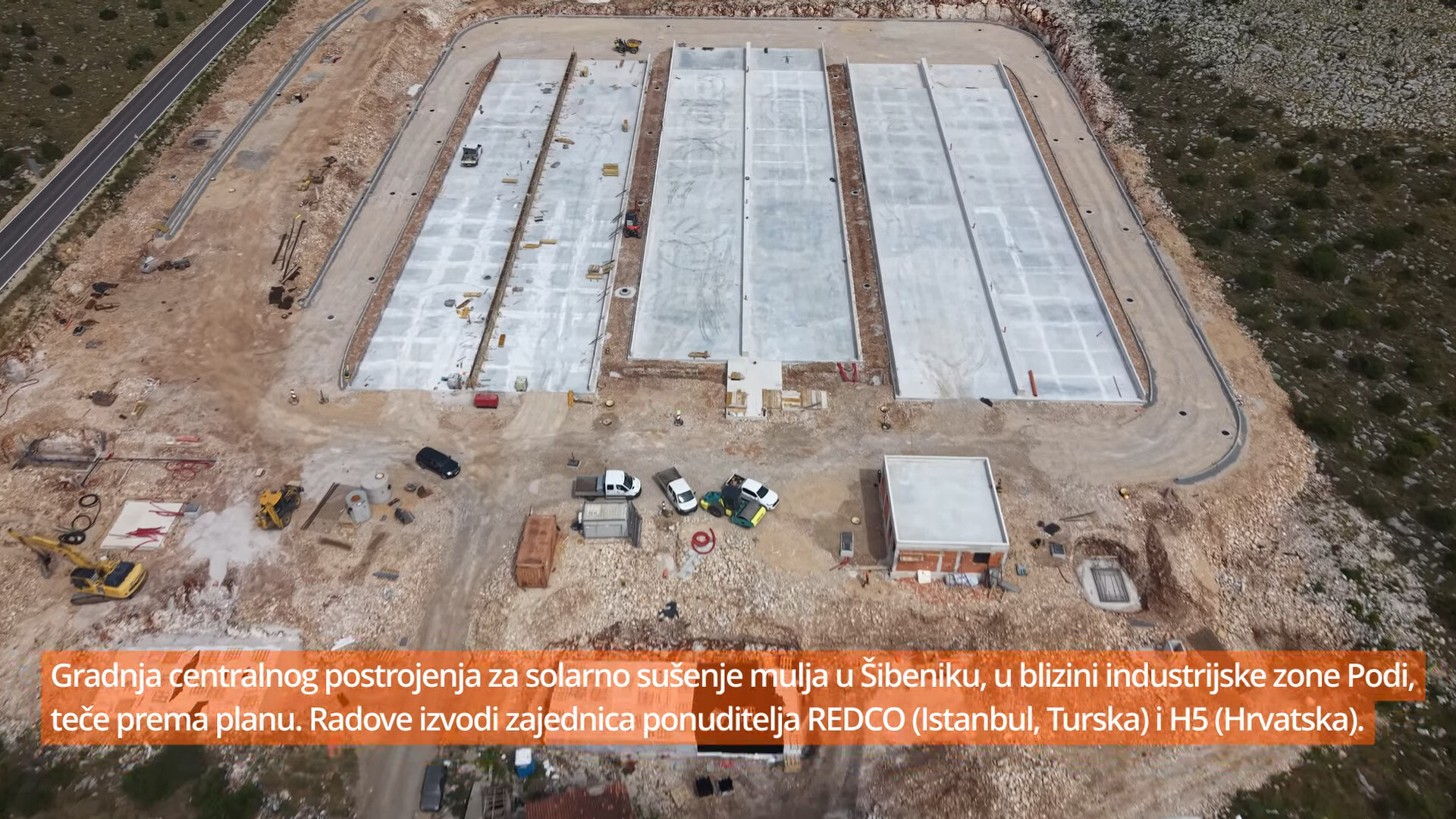 Snimka iz zraka gradilišta solarnog sušenja mulja kraj industrijske zone Podi, vidi se šest paralelnih betonskih ploča pripremljenih za montažu hala.