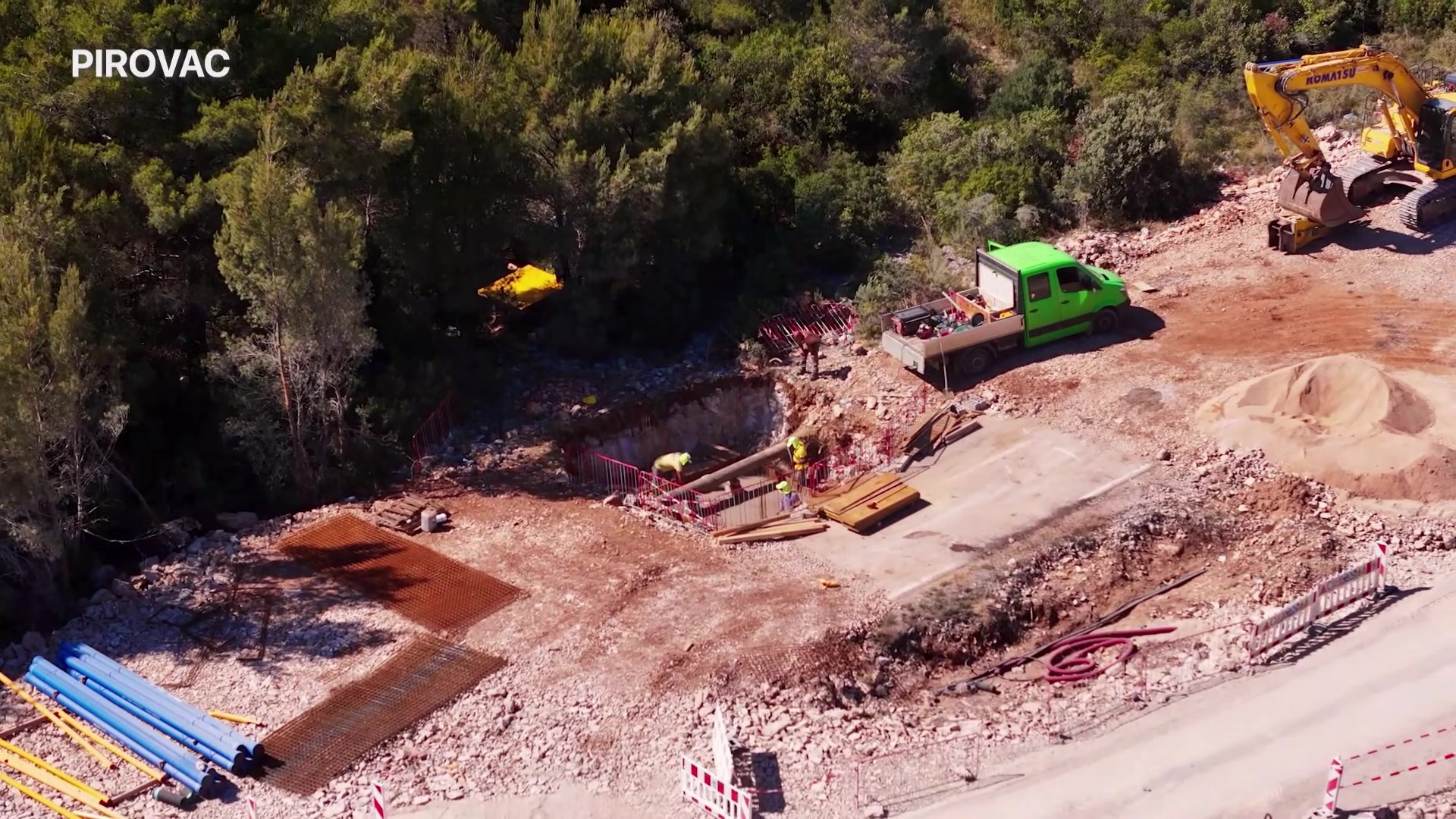 Zračna snimka gradilišta: bager i cijevi na trasi nove ceste