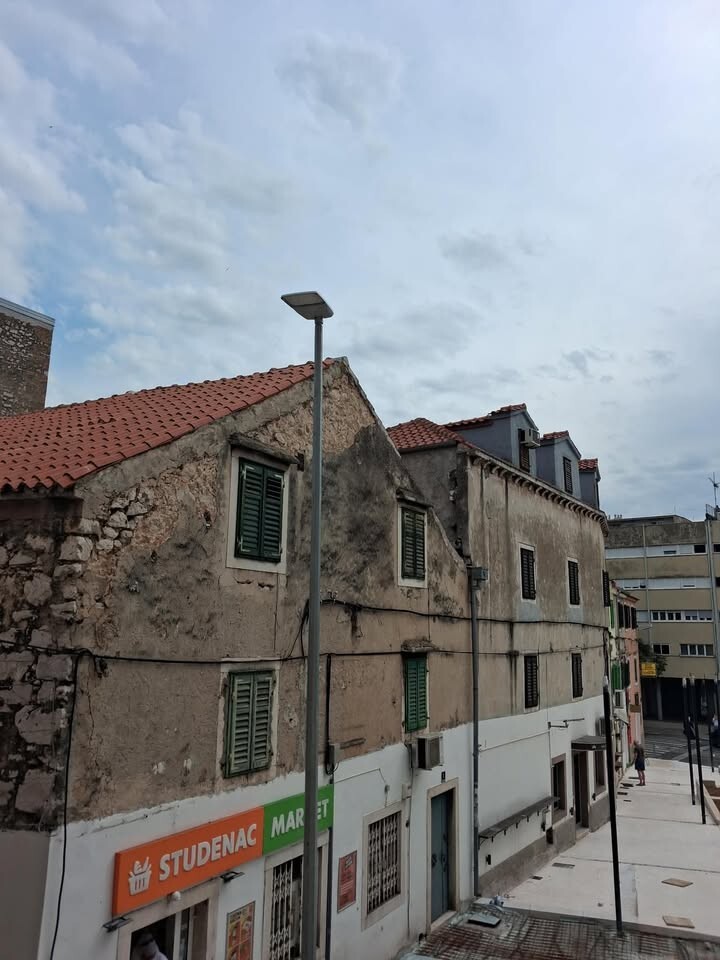 Stup javne rasvjete na novouređenom trgu na Vanjskom, postavljen u visini prozora stambene zgrade