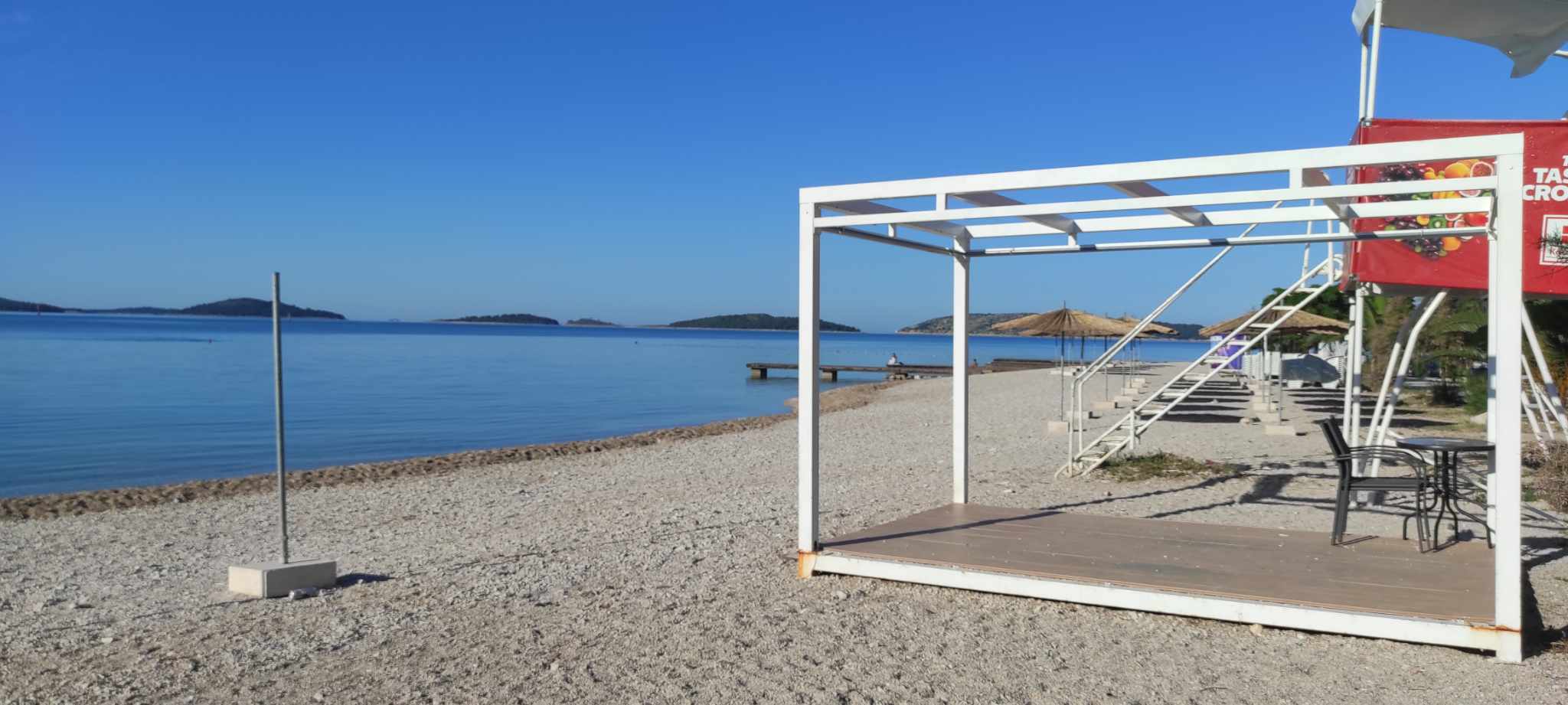 Bijela nadstrešnica s ležaljkama na plaži