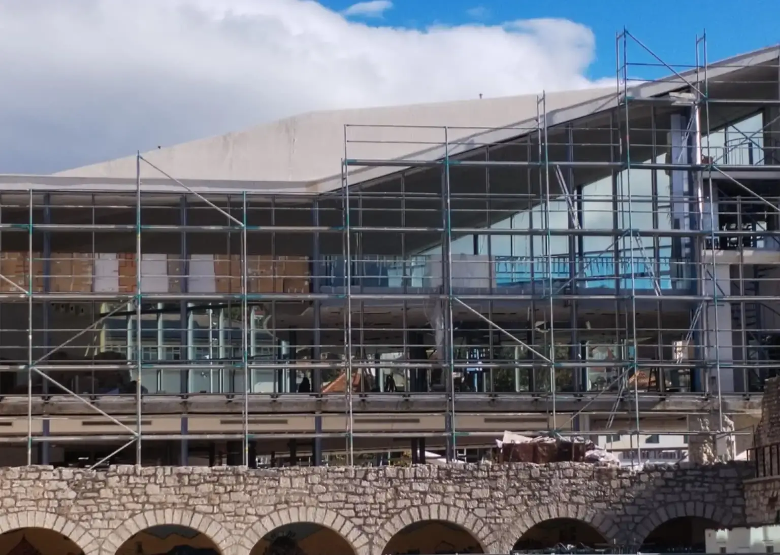 Zgrada knjižnice u skelama, bez stakala na pročelju, ljeto 2025.