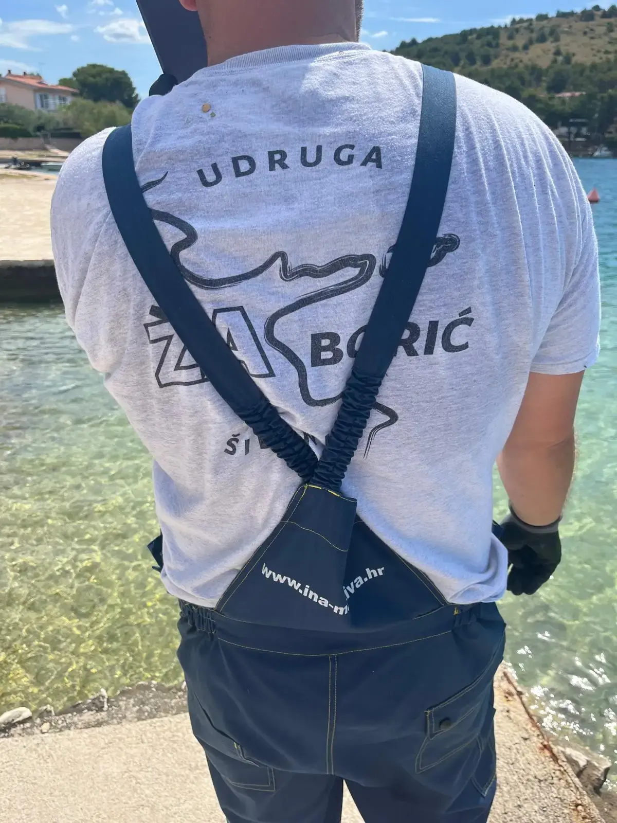 Volonter u majici Udruge Za Žaborić okrenut prema moru