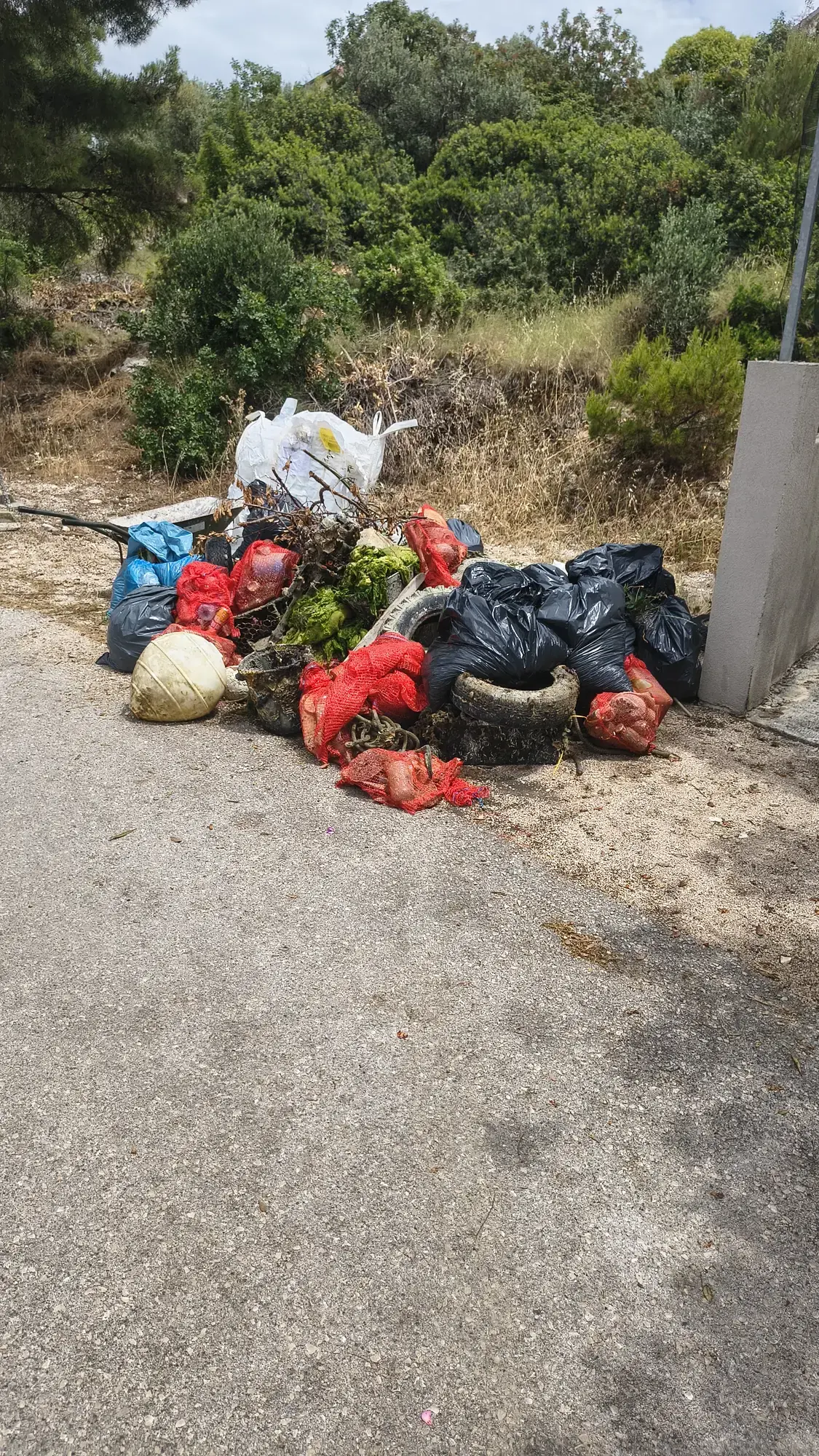 Vreće prikupljenog otpada i guma uz cestu