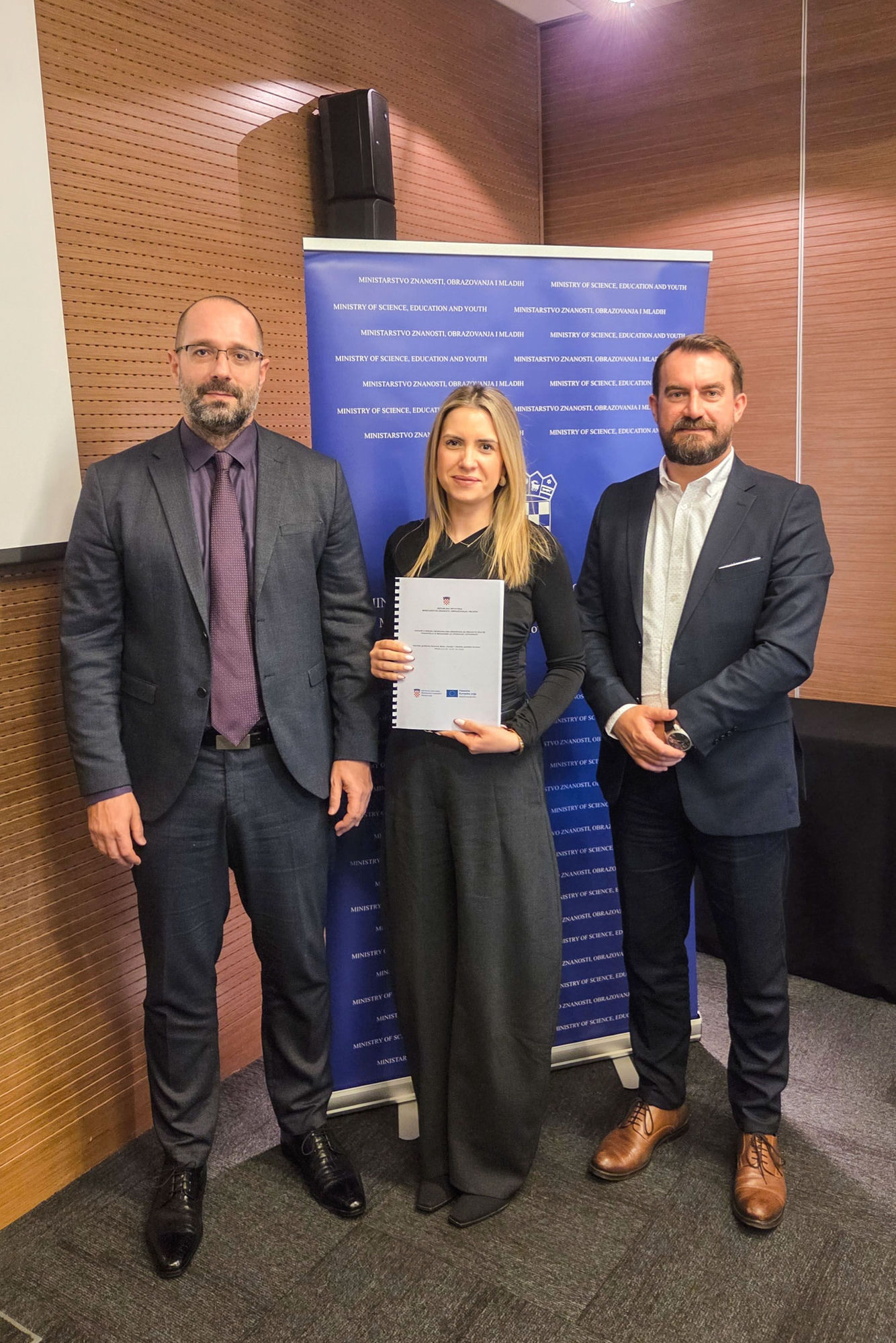 Danijel Mileta, Maja Čeko i ravnatelj Komadina poziraju s potpisanim ugovorom ispred banera Ministarstva