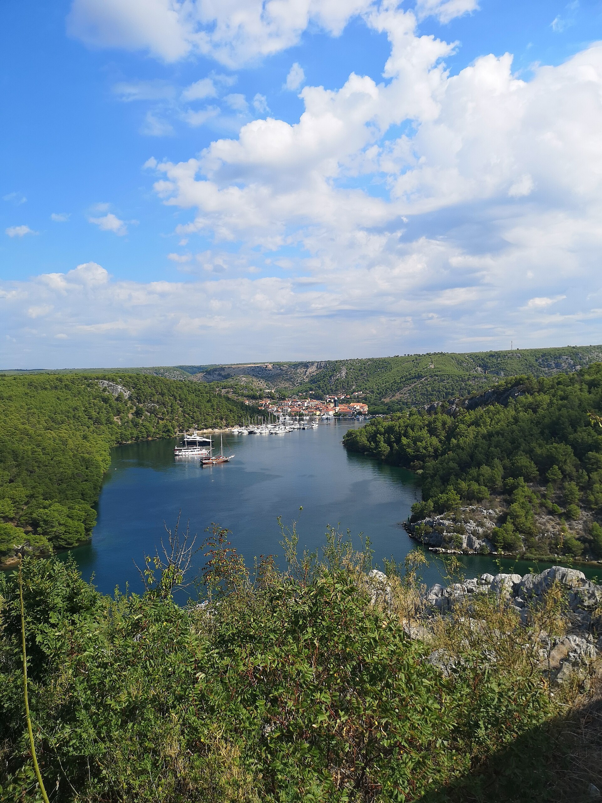 Skradin na ušću Krke, gradić s marinom i brodicama okružen zelenilom.
