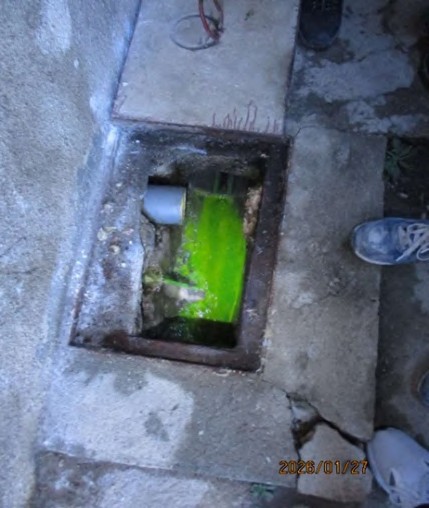 Šahta s PVC cijevi iz WC-a i zelenom tekućinom koja izlazi iz betonskog kanala ispod kade