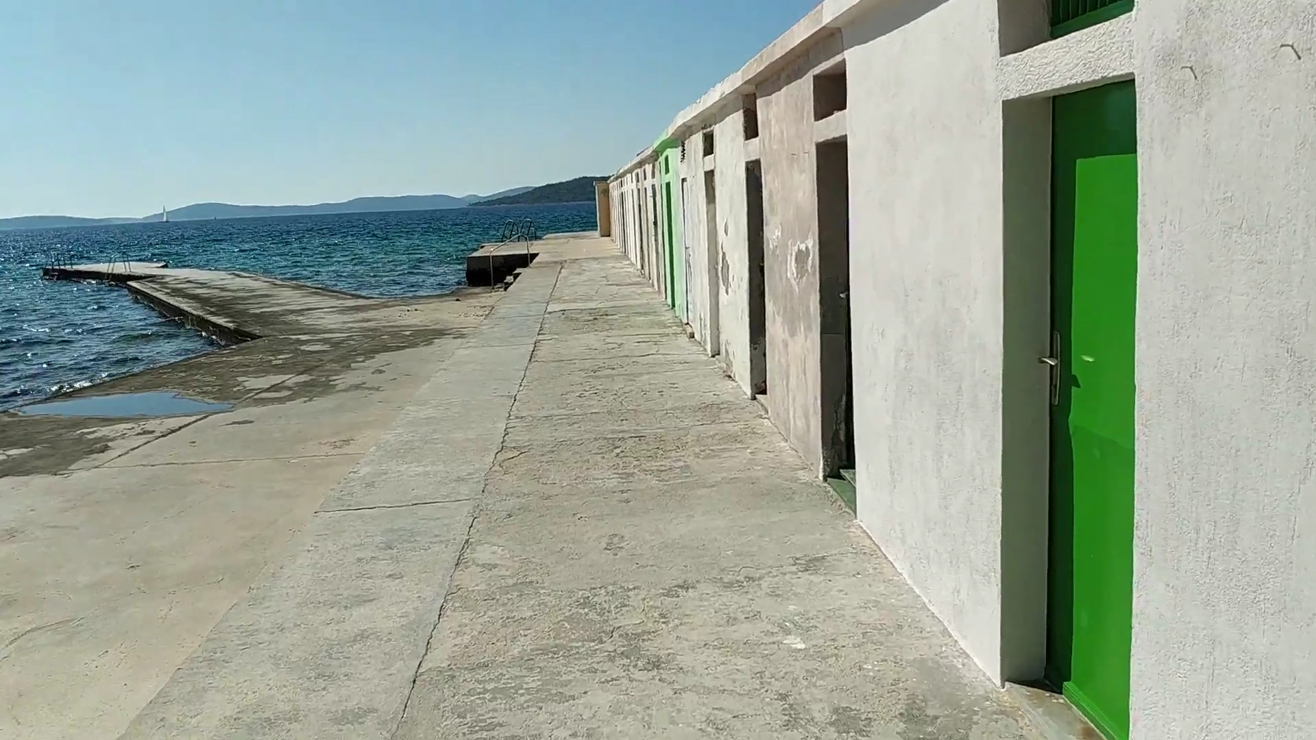 Niz kabina s obojenim vratima uz šetnicu na Jadriji