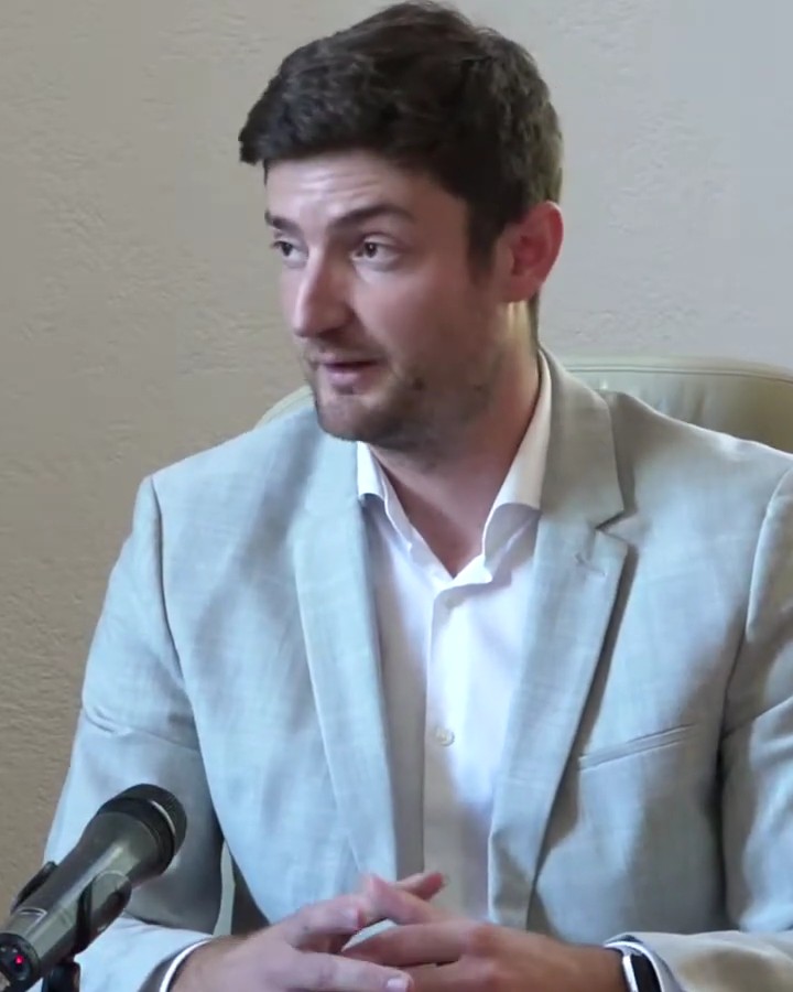 Kristijan Stipaničev u svijetlom sakou za stolom s mikrofonom