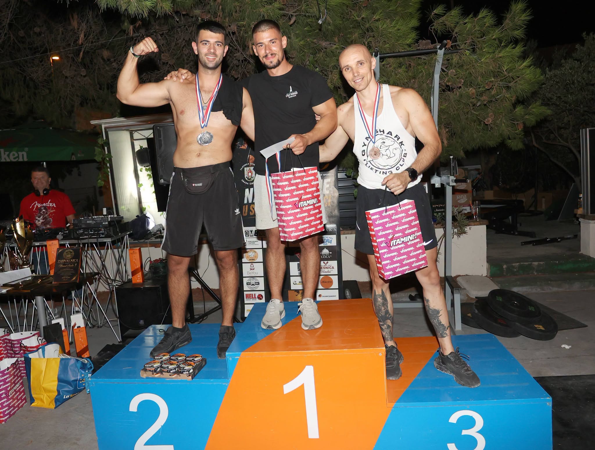 Grupa natjecatelja pozira na postolju s medaljama