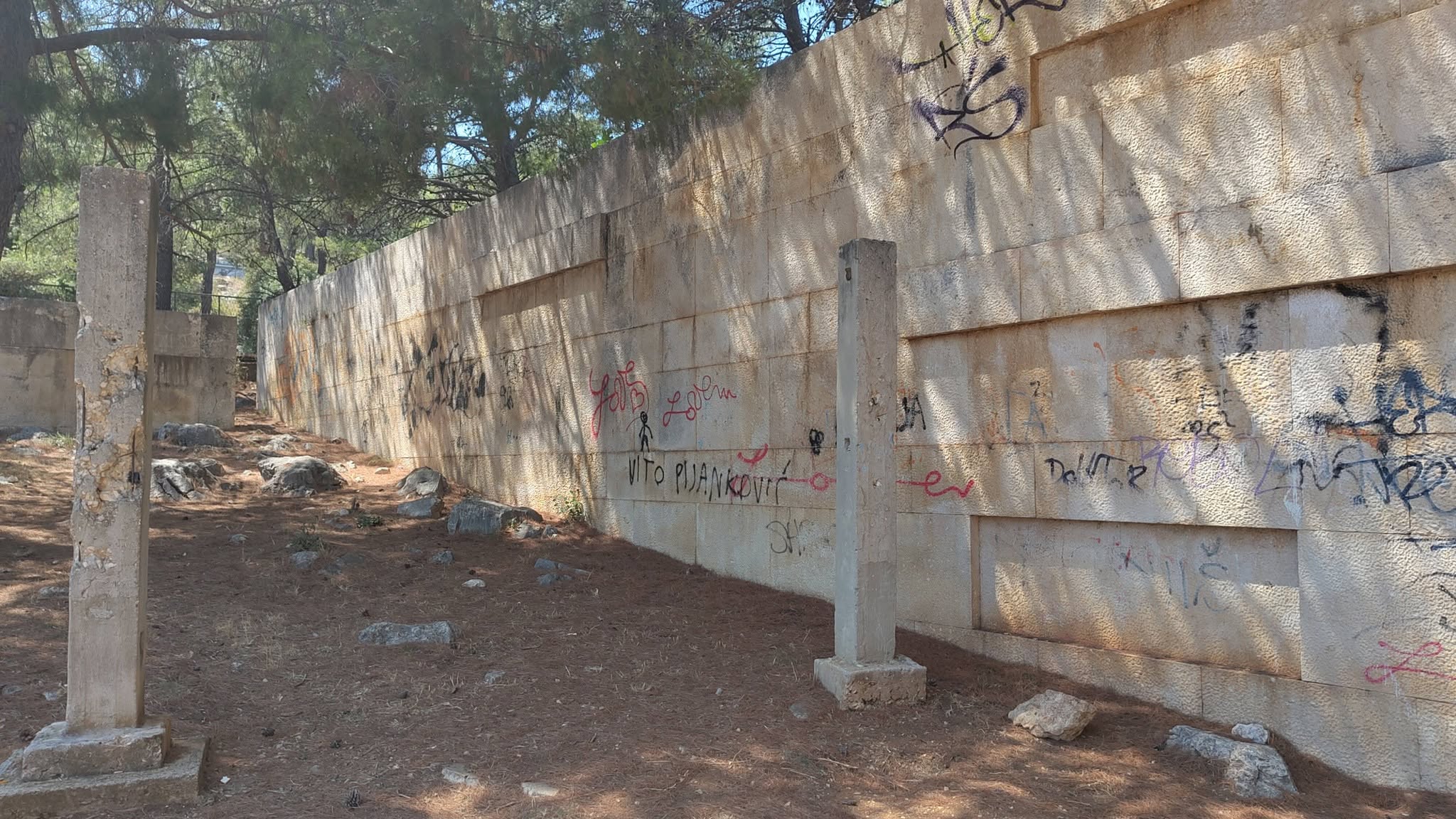 Grafiti po kamenom zidu uz stupove strijeljanja